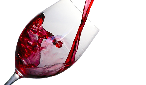 a glass of red wine being poured